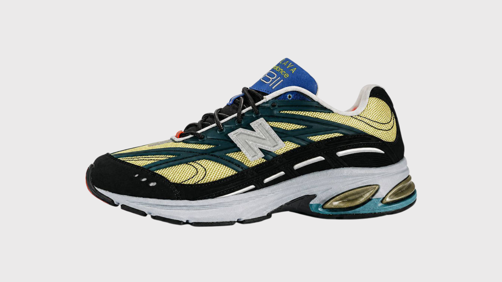 Action Bronson x New Balance 2811 en vista de tres cuartos, con malla amarilla, paneles verde azulado y lengüeta azul con el logo Baklava