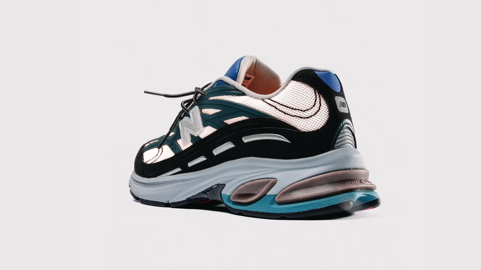 Action Bronson x New Balance 2811 vista trasera, con talonera blanca y negra, detalles turquesa y entresuela con cápsulas Abzorb