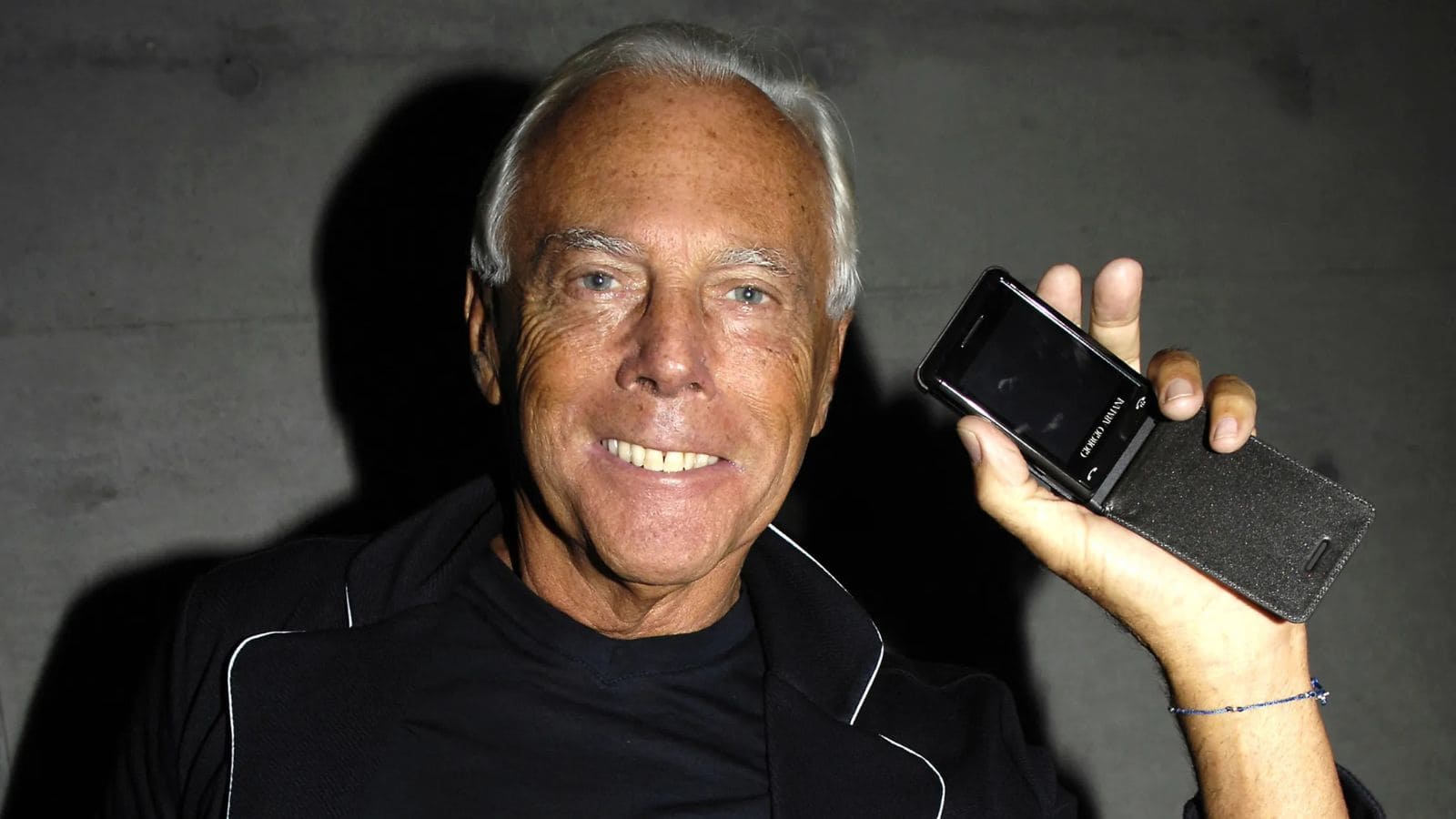 Giorgio Armani sosteniendo un teléfono móvil de lujo durante la era 2000