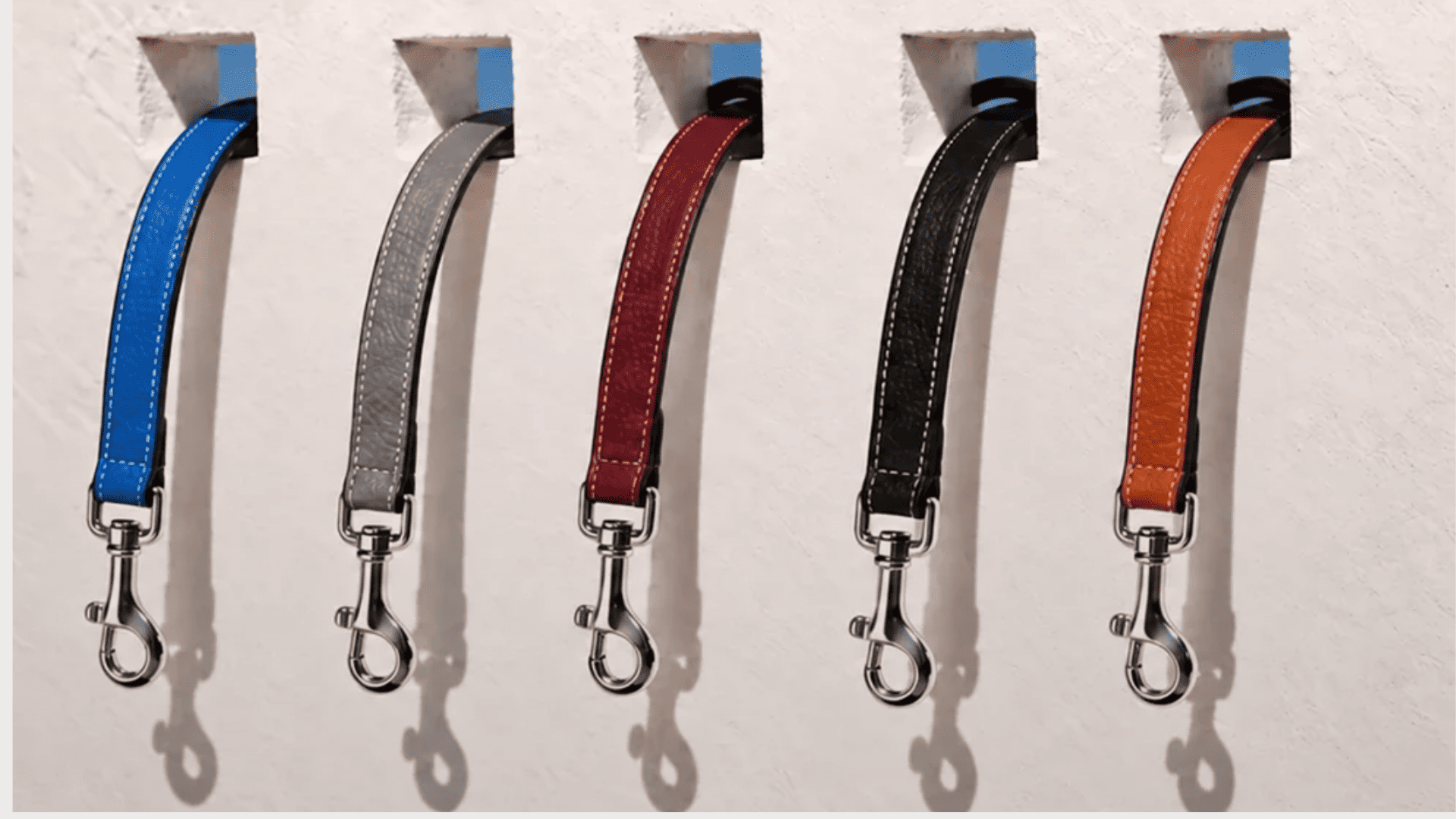 Correas de piel para perros OBALOVA en cinco colores colgadas en pared de taller